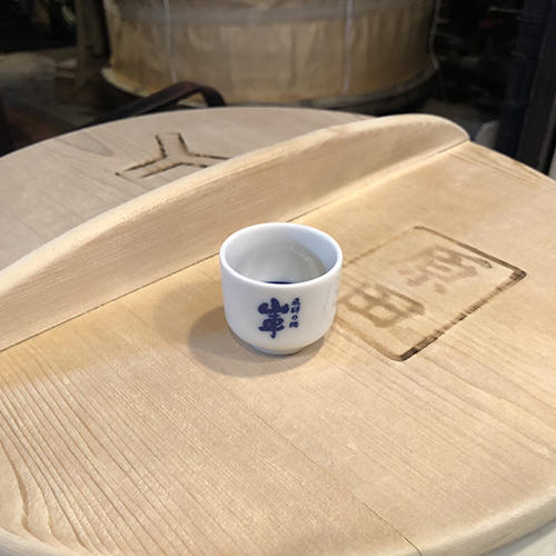 a sake cup sitting on a barrel